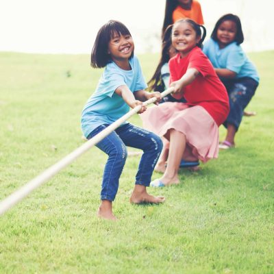 Children group playing tug of war at the park Children group playing tug of war at the park